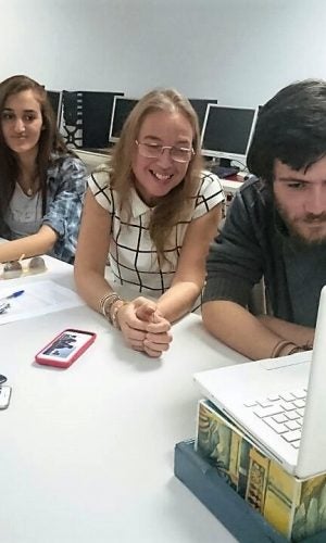 Students and a teacher at the American University of Technology in Lebanon interacting with students in New York through their laptop.