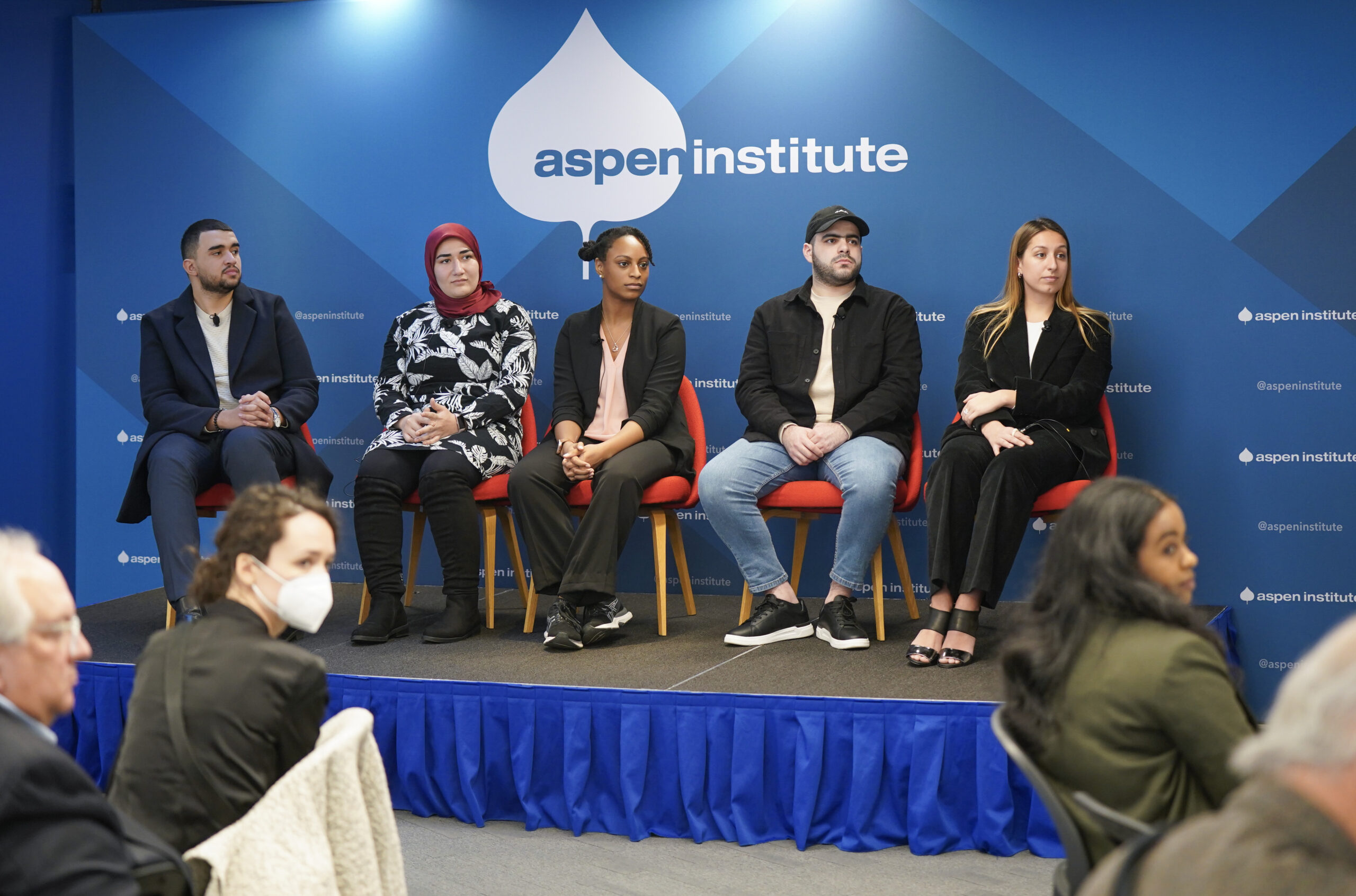 Five people sitting in chairs on a stage in the Aspen Institute