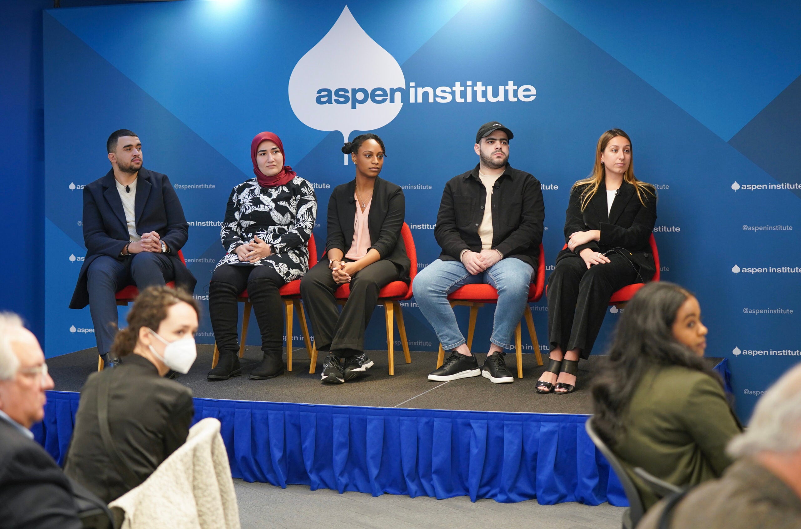 Five people sitting in chairs on a stage in the Aspen Institute