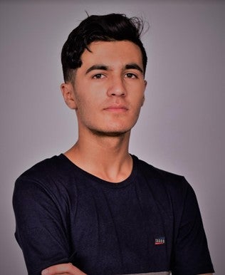 Young man standing in front of a gray background