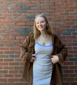 A woman standing in front of a brick wall