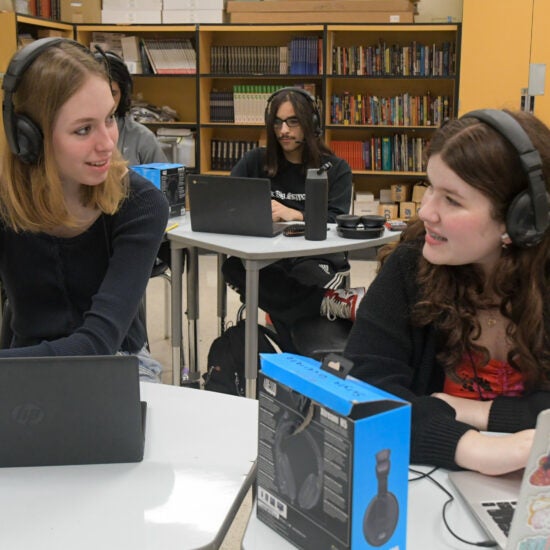 Three students sitting in a classroom - Eleanor, Mizael, and Alina