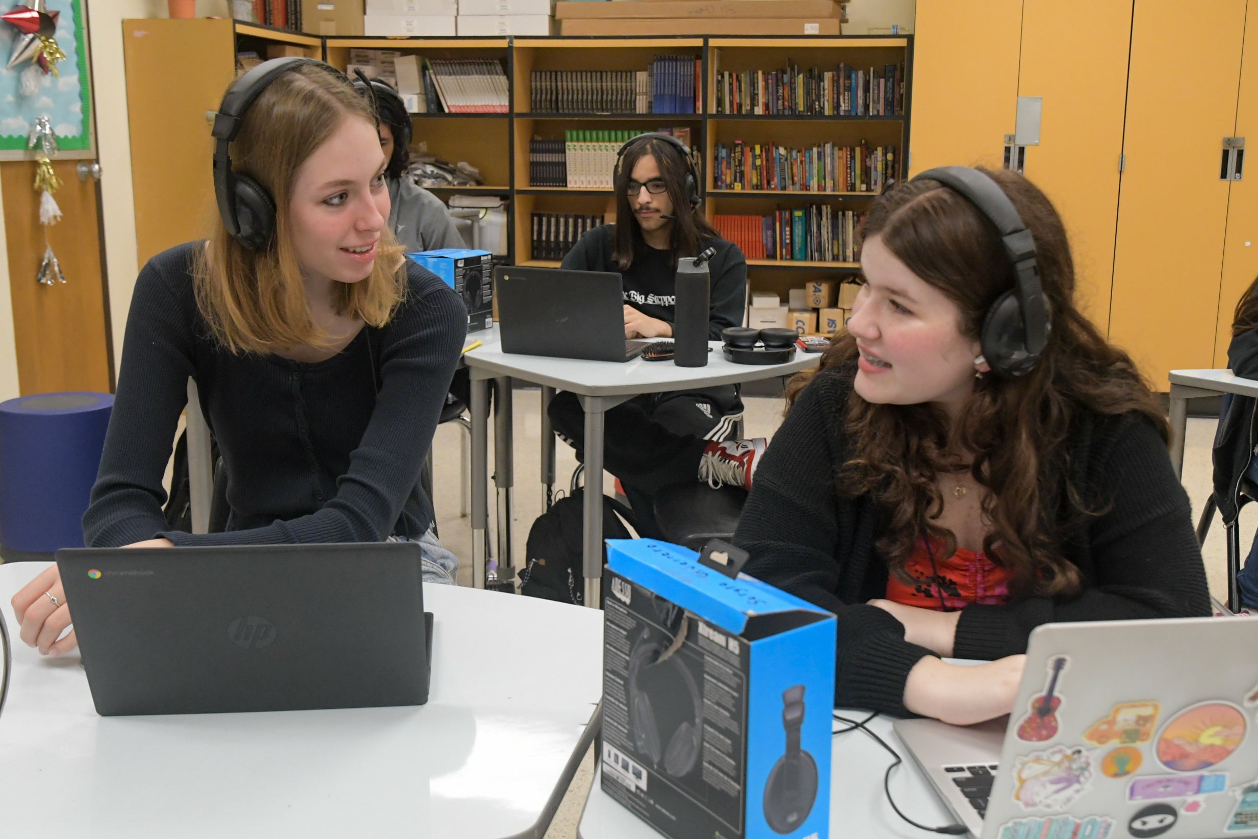 Three students sitting in a classroom - Eleanor, Mizael, and Alina