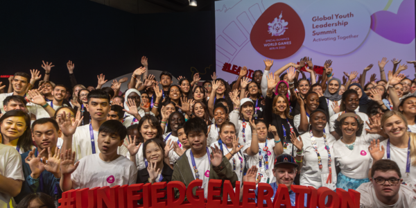 A group of young people with a special olympics sign.