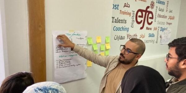 A group of students around a white board.
