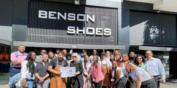 A group of young students posing for a photo together outside a storefront called Benson Shoes.